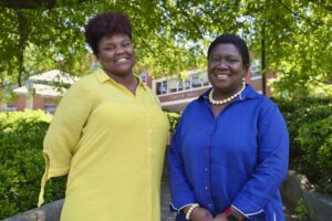 Samaya Brooks, left, and Dr. Kenrett Jefferson-Moore, right, standing outdoors in front of Carver Hall at North Carolina A&T State University. Both are smiling, with Samaya wearing a yellow blouse and Dr. Jefferson-Moore in a blue blouse with a pearl necklace.